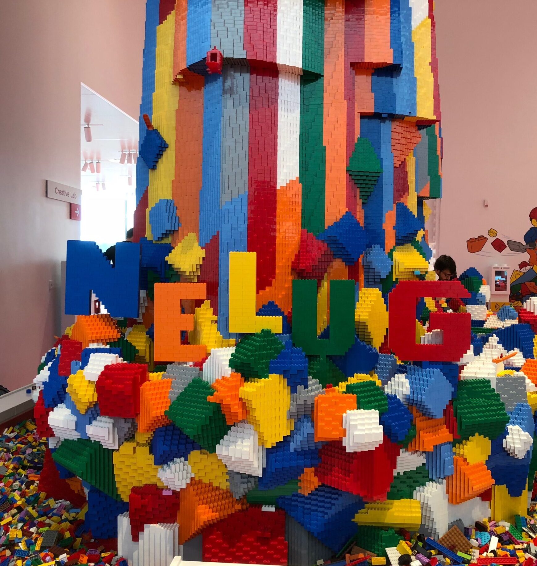 Waterfall built of colorful LEGO bricks, including NELUG lettering, also made of bricks.
